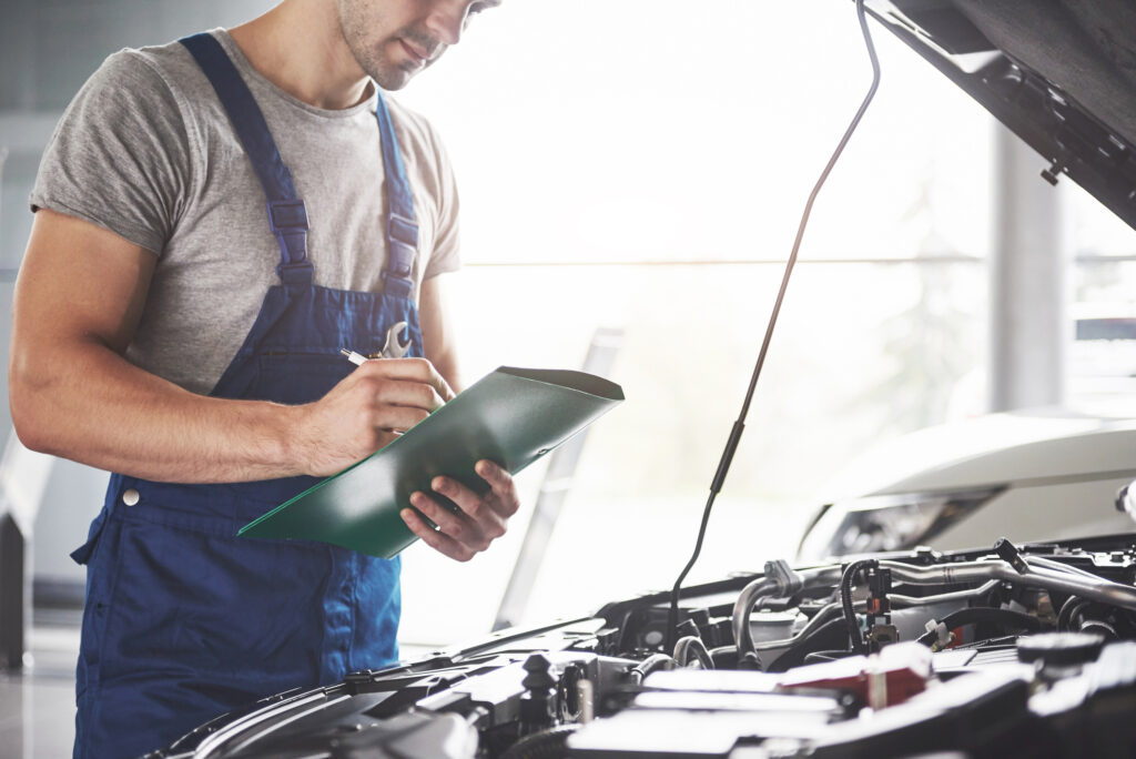KfZ Gutachter Ilmenau - Porträt eines Mechanikers bei der Arbeit in seiner Garage - Auto-Service, Reparatur, Wartung und Menschen-Konzept